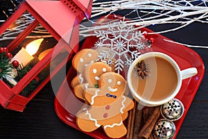 Top view three Gingerbread men cookies with coffee on red dish