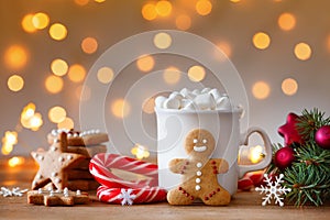 Gingerbread man, cup of hot cocoa with marshmallow and Christmas fir branch photo