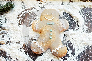 Gingerbread man making snow angel on flour