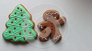 Gingerbread Man And Pine Tree Cookies With Decorative Icing On White Surface