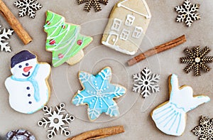Gingerbread painted colored gingerbread cookies and spices and snowflakes on a craft background close-up. Christmas