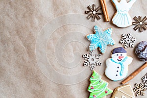 Gingerbread painted colored gingerbread cookies and spices and snowflakes on a craft background close-up. Christmas