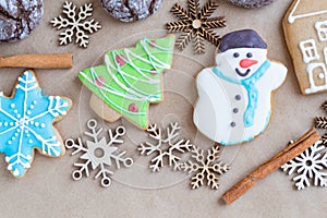 Gingerbread painted colored gingerbread cookies and spices and snowflakes on a craft background close-up. Christmas