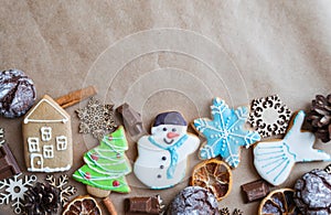 Gingerbread painted colored gingerbread cookies and spices and snowflakes on a craft background close-up. Christmas