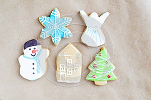 Gingerbread painted colored gingerbread cookies and spices and snowflakes on a craft background close-up. Christmas celebration