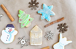 Gingerbread painted colored gingerbread cookies and spices and snowflakes on a craft background close-up. Christmas celebration