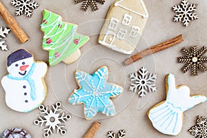 Gingerbread painted colored gingerbread cookies and spices and snowflakes on a craft background close-up. Christmas celebration