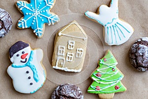 Gingerbread painted colored gingerbread cookies and spices and snowflakes on a craft background close-up. Christmas celebration