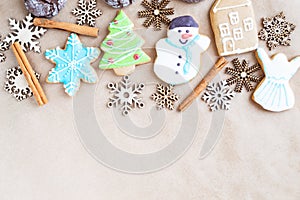 Gingerbread painted colored gingerbread cookies and spices and snowflakes on a craft background close-up. Christmas celebration