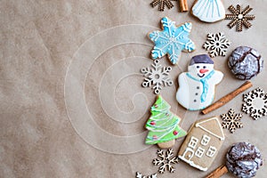 Gingerbread painted colored gingerbread cookies and spices and snowflakes on a craft background close-up. Christmas celebration