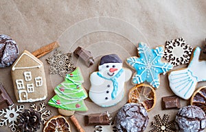 Gingerbread painted colored gingerbread cookies and spices and snowflakes on a craft background close-up. Christmas celebration