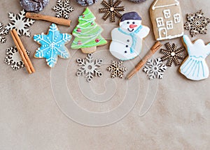 Gingerbread painted colored gingerbread cookies and spices and snowflakes on a craft background close-up. Christmas celebration