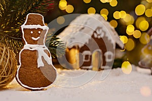 Gingerbread snowman and snow decoration for Christmas and New Year, dark background, selective focus, bokeh. Christmas food. Snowm