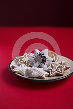 Gingerbread stars with white icing and chocolate sprinkles on red background
