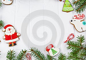 Gingerbreads and branches of fir tree on white table. Christmas greeting card, mockup with copy space.