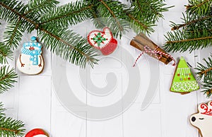 Gingerbreads and branches of fir tree on white table. Christmas greeting card, mockup with copy space.