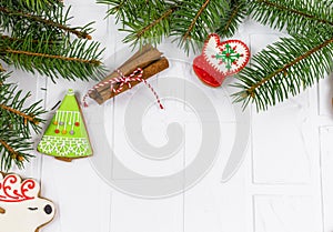 Gingerbreads and branches of fir tree on white table. Christmas greeting card, mockup with copy space.