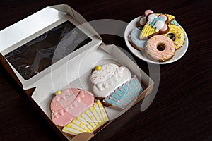 Gingerbreads in the form of a donuts, ice cream, and cakes on white saucer.