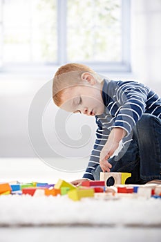 Gingerish boy playing with cubes