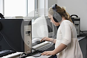 Girl (10-12) with Down syndrome recording sound in home studio