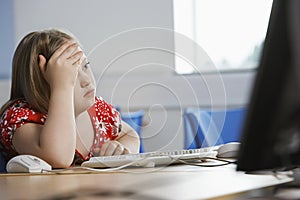 Girl (10-12) with Down syndrome sitting in computer lab