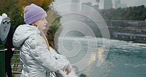 A girl of 10 years old stands at Niagara Falls, admiring the beautiful view. Travel in the USA