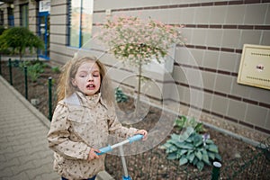 Girl of 7-8 years goes on the sidewalk and bitterly cries.