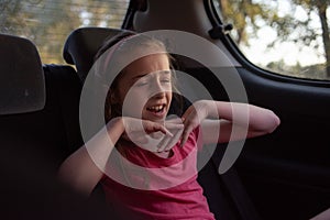 A girl of 8-10 years old rides in a car. Exploring nature, travel, family vacation. A girl of 9 years old rides in a car