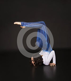 Girl acrobat, gymnastics, a young athlete in a blue and white suit , practicing acrobatics.  images on white background
