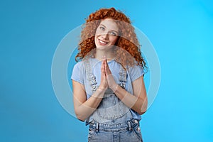 Girl acting like nun redhead cute curly female press palms together pray supplication gesture tilting head silly smiling