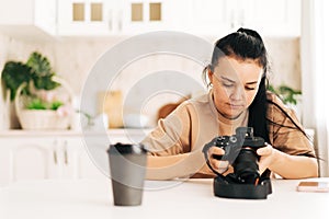 Girl adjusts the camera sitting at a white table