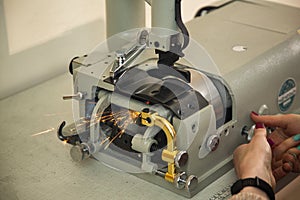 The girl adjusts the sharpening of a knife in a lathe