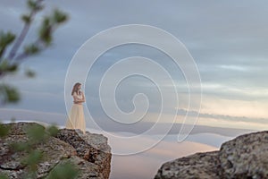 A girl admiring the dawn or sunset of the sun in a picturesque place in the mountains.