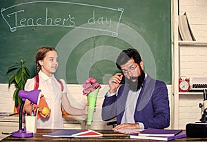 Girl adorable pupil with backpack carry bouquet flowers for teacher. Back to school. Knowledge day congratulations