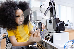 Girl with afro hairstyle wear yellow T-shirt engineer with robot for education on table at class room. Robotics learning