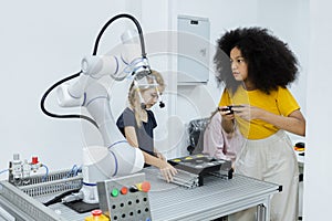 Girl with afro hairstyle wear yellow T-shirt using joystick control smart robotics arm at class room. electric system skill