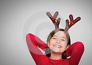 Girl against grey background with reindeer antlers