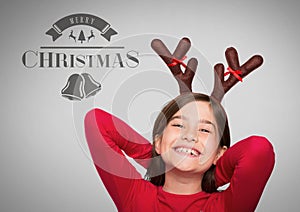 Girl against grey background with reindeer antlers and Merry Christmas text