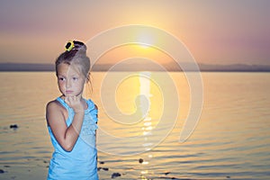 Girl against a pink sunset over salt lake