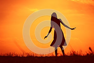 Girl against sunset skies