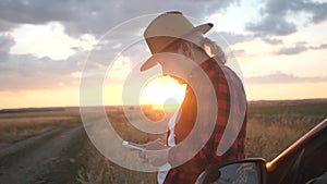 Girl agronomist with a smartphone analyzes the development of crops.