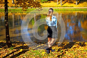 A girl alone in the autumn Park by the pond. Autumn nature background