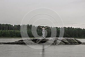 A girl alone on a rock, rock in the middle of a lake