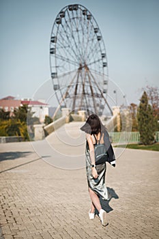 Girl in an amusement Park with a Ferris wheel in the background. Weekends are for entertainment and great time