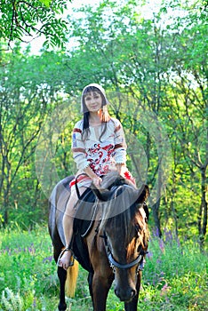 Girl in an ancient russian attire riding a horse