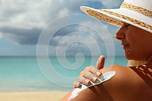 Girl aplying sun protection cream photo