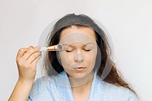 The girl applies a tonal corrective cream on a problematic pigmentation face.