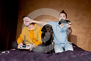 A girl applies a trick in a game with a guy, a dog sits next to them