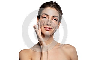 Girl applying coffee scrub, natural peeling mask on face skin.