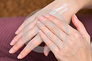 Girl applying cream on hands